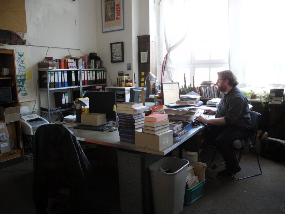 Der Verleger in seinem Büro bei der Arbeit.