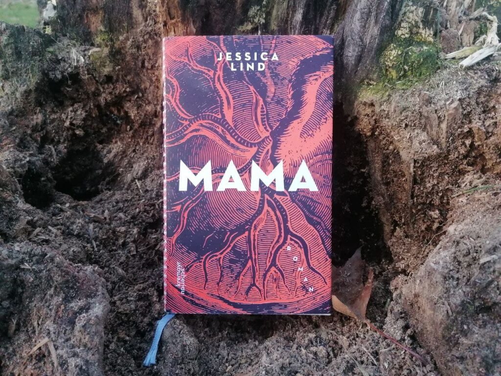 Das Buch "Mama" geschlossen auf einem Baumstumpf.